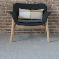 chair sitting on shaw carpet with brick wall behind
